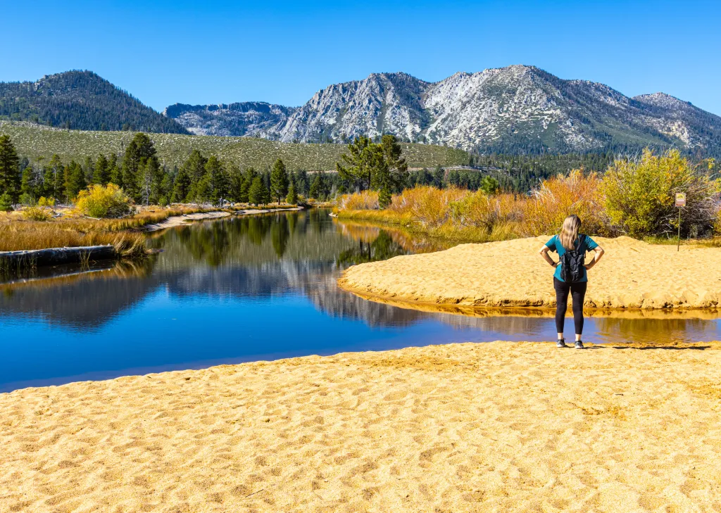 Female hiker on the sandy shore of Kiva Beach in Lake Tahoe, California.
