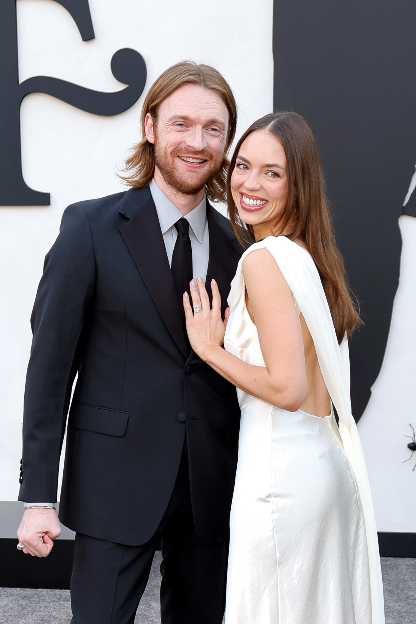 Finneas O'Connell and Claudia Sulewski smiling at the Los Angeles Premiere of Netflix's