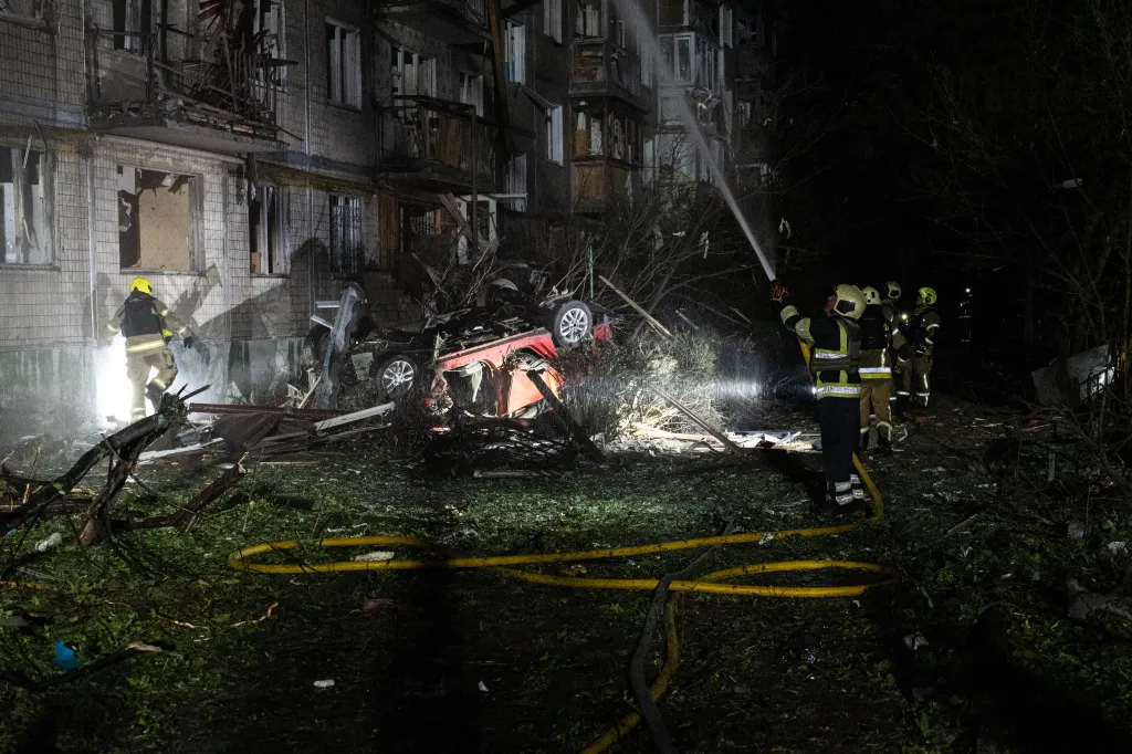 A car is flipped on its roof in a pile of debris near the site where a Russian missile struck in Kyiv, Ukraine.