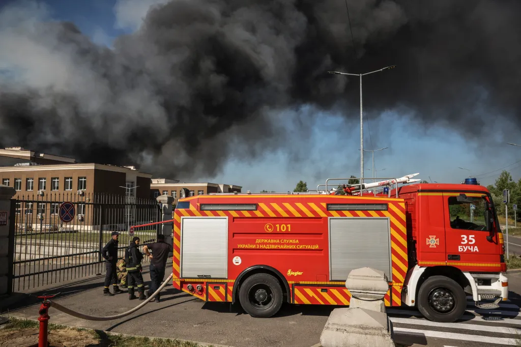 Firefighters respond to a drone strike in the Kyiv region, with thick black smoke rising from the affected building.