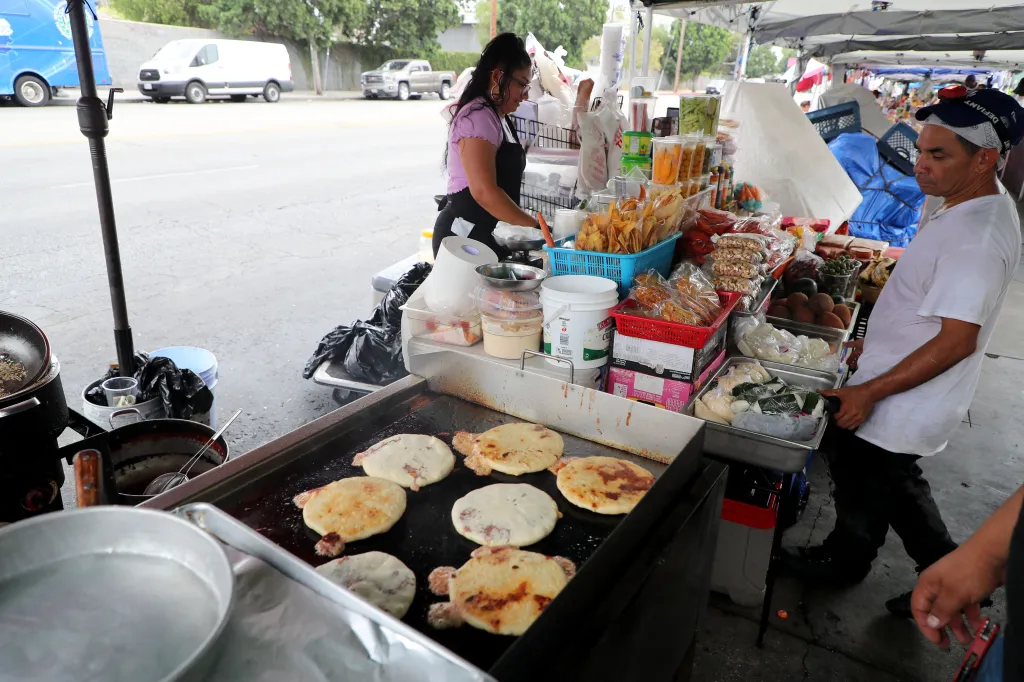 Food vendors cooking pupusas and selling various snacks on the Salvador Corridor in Los Angeles.