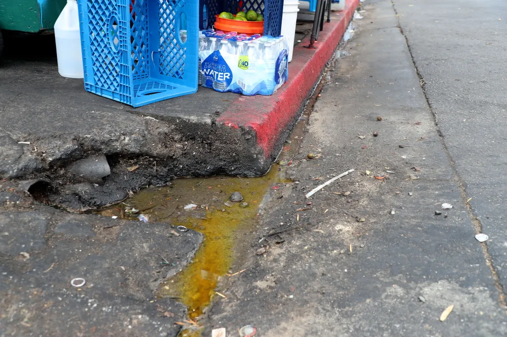 Puddles of dirty water and refuse on a street in Los Angeles, California.