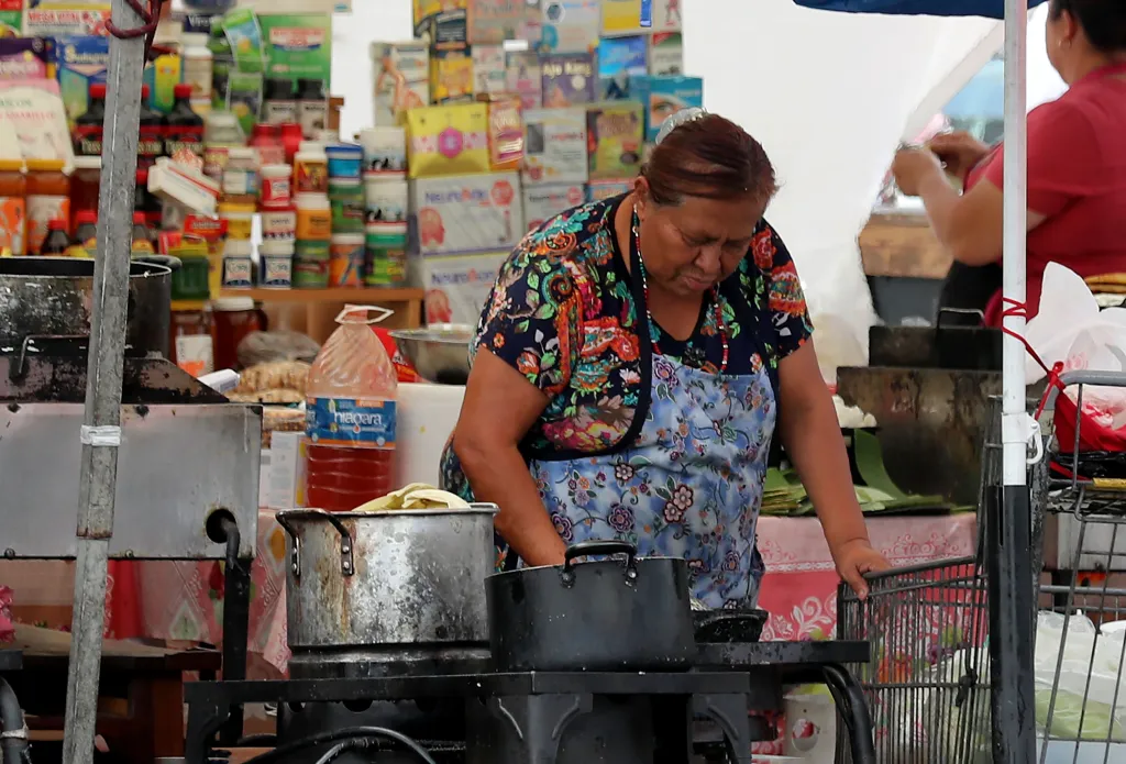 A food vendor cooking on a street stall at the Salvador Corridor in Los Angeles.