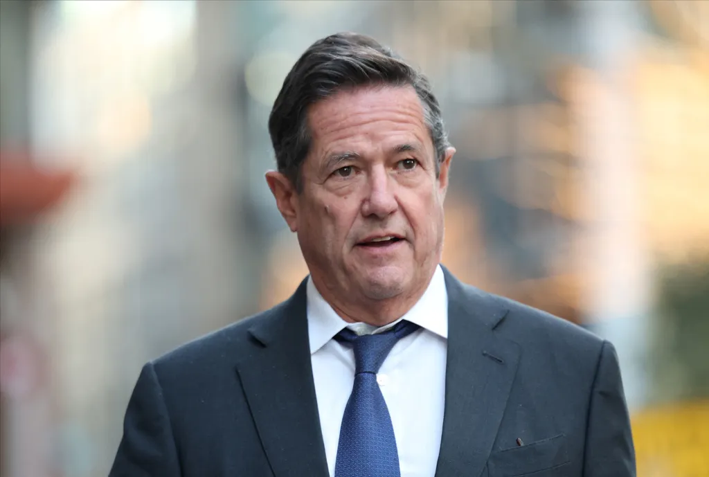 Former Barclays CEO Jes Staley in a suit and tie leaving court.