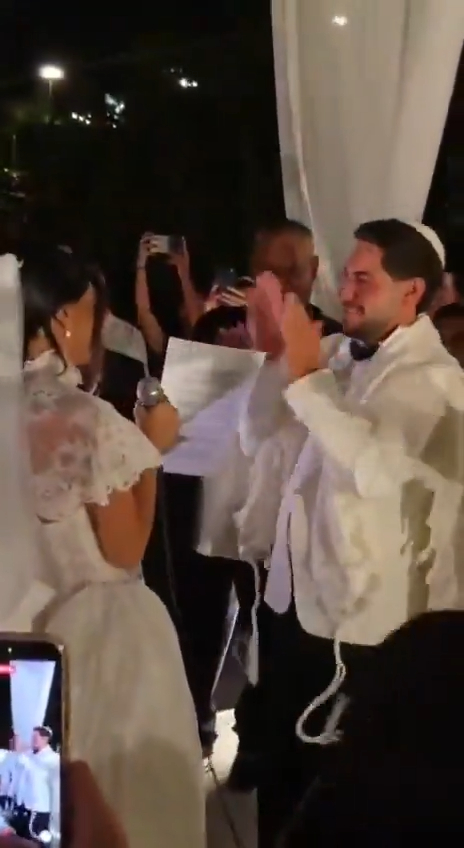 Eliya Cohen and Ziv Abud, in wedding attire, during their marriage ceremony.