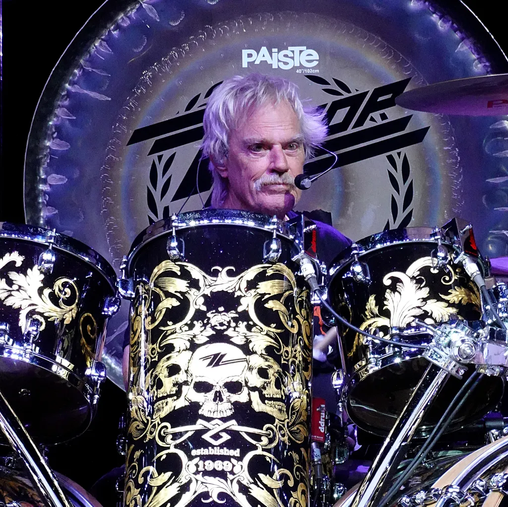 ZZ Top's Frank Beard plays drums with a large Paiste gong behind him.