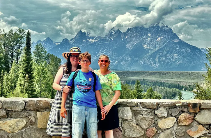 Melissa Dalley (left) with a boy and another woman in front of Grand Teton mountains.