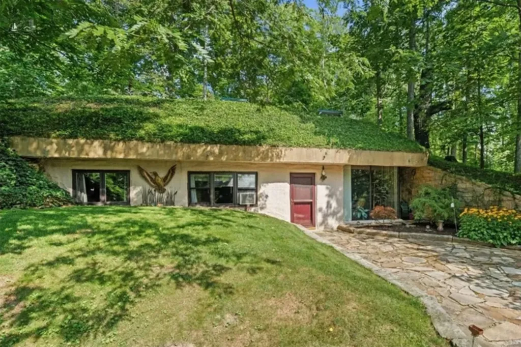 An earth-sheltered home in Huron, Ohio, with a grass-covered roof and a stone path leading to the front door.