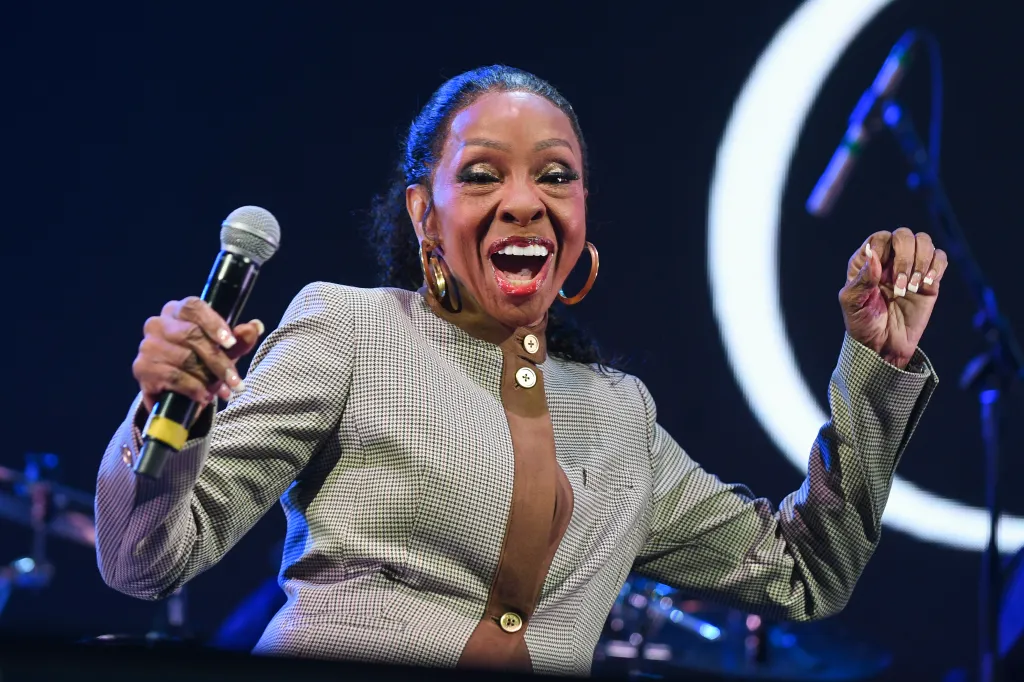 Gladys Knight performs onstage, holding a microphone.