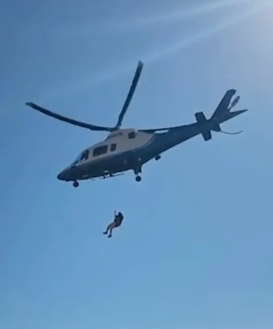 Glen Keane being hoisted by a helicopter during a rescue.