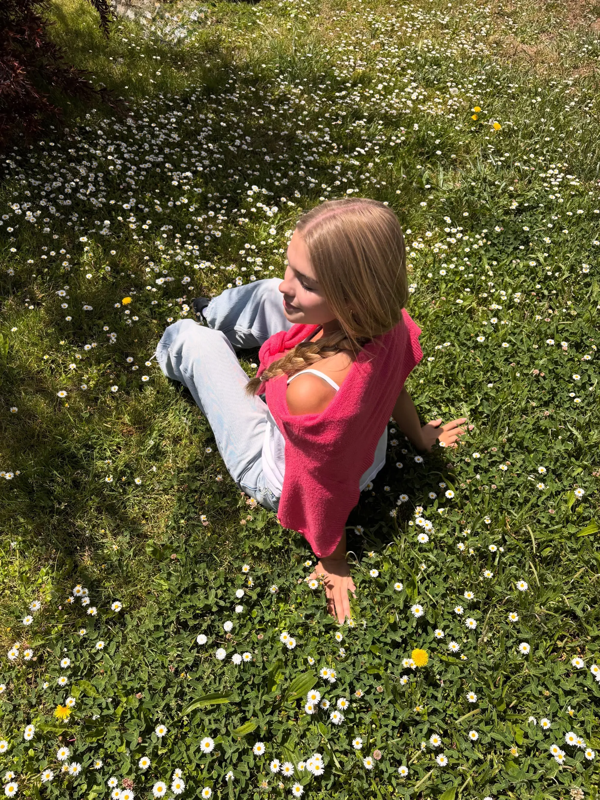 Mia Talerico, a child star, is seen in a sunny field of daisies and grass.