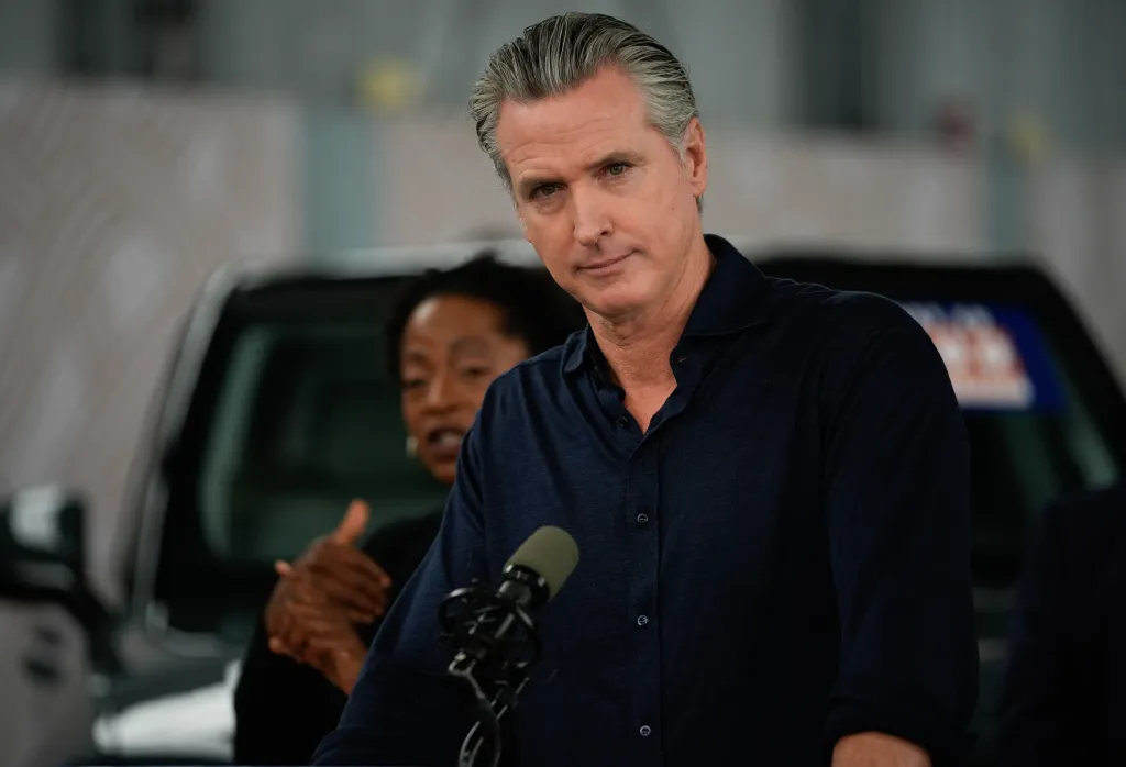 Governor Gavin Newsom speaking at a press conference in Oakland about clean energy and EV savings.