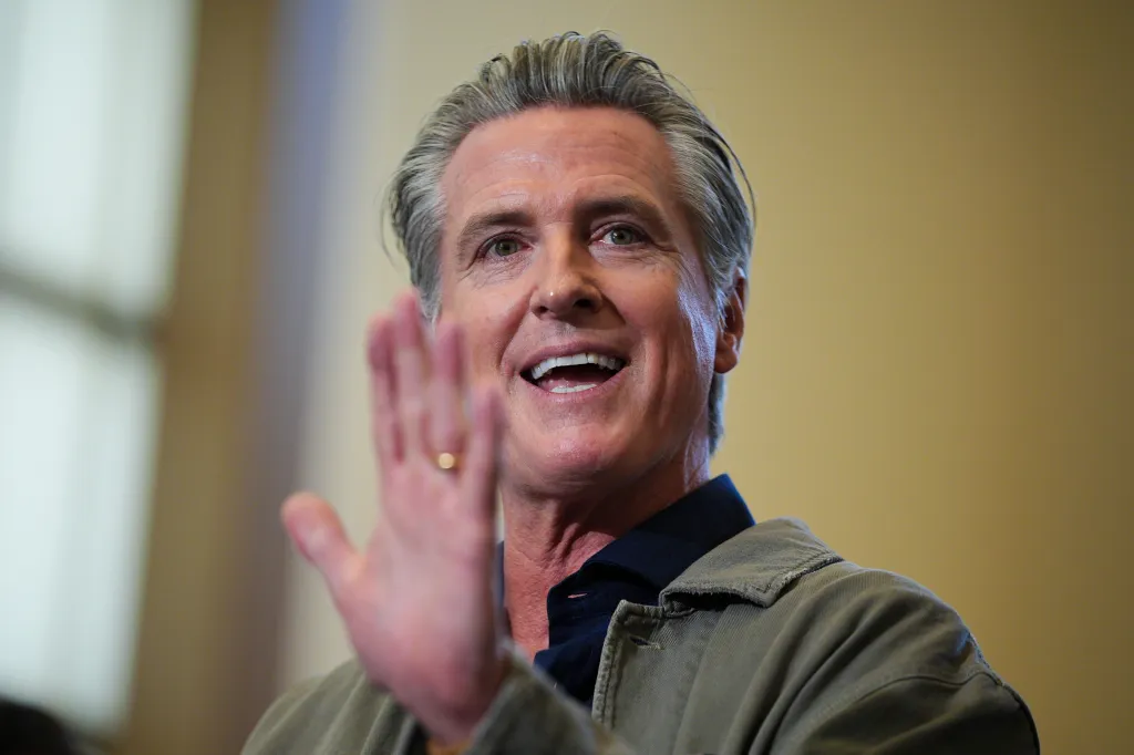 Governor Gavin Newsom waves to the crowd while speaking at Schafer Park Elementary School.