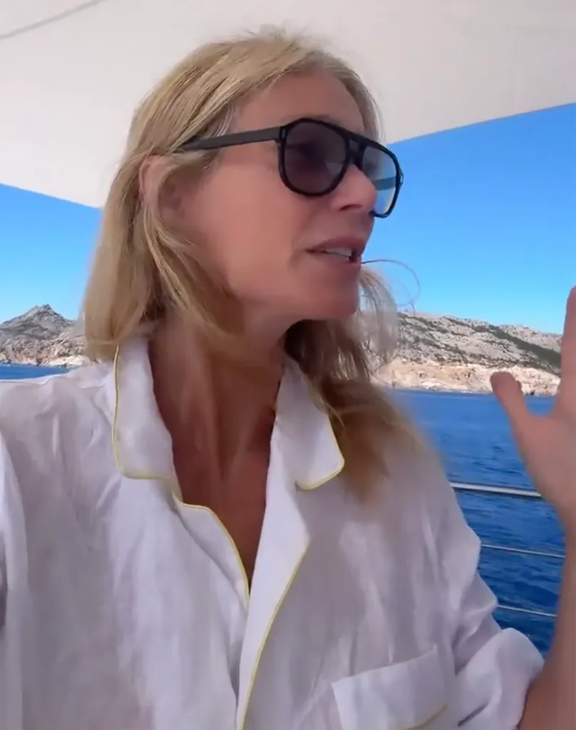 Gwyneth Paltrow wearing sunglasses and a white shirt on a boat.