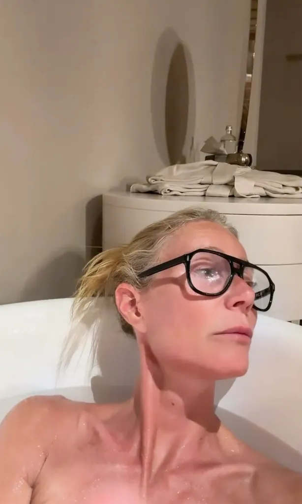 Gwyneth Paltrow takes a bath while wearing glasses.