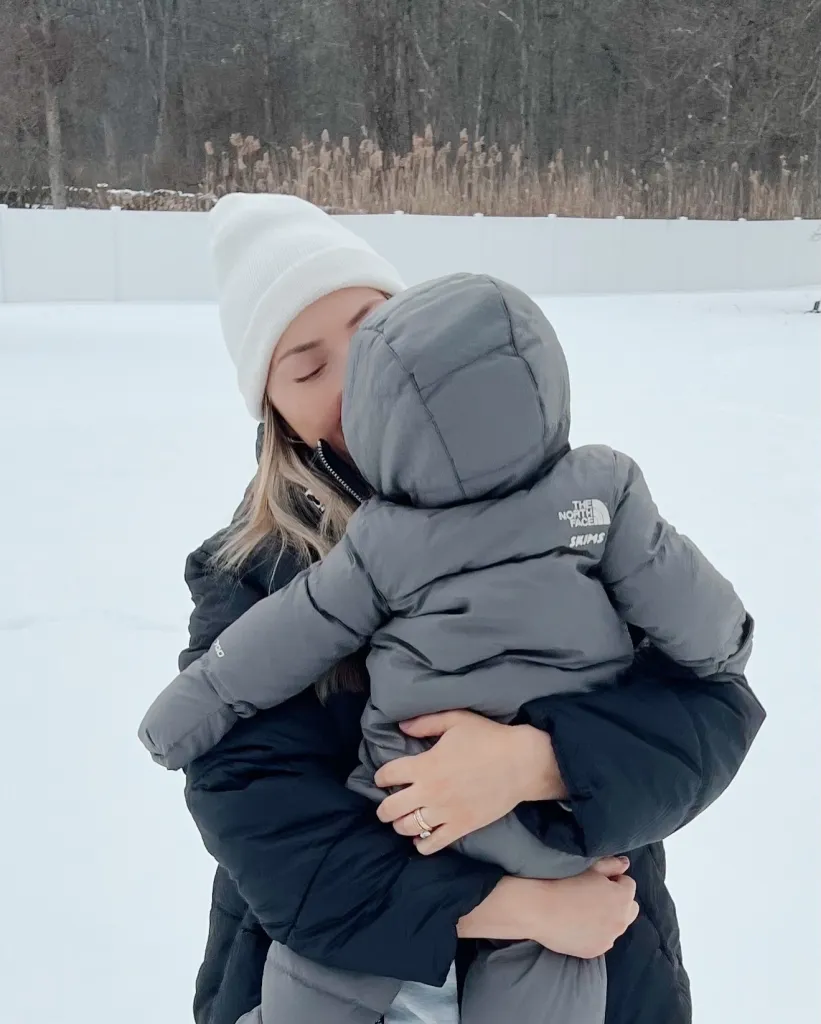 Hailie Jade Scott holding her baby on a snow day.