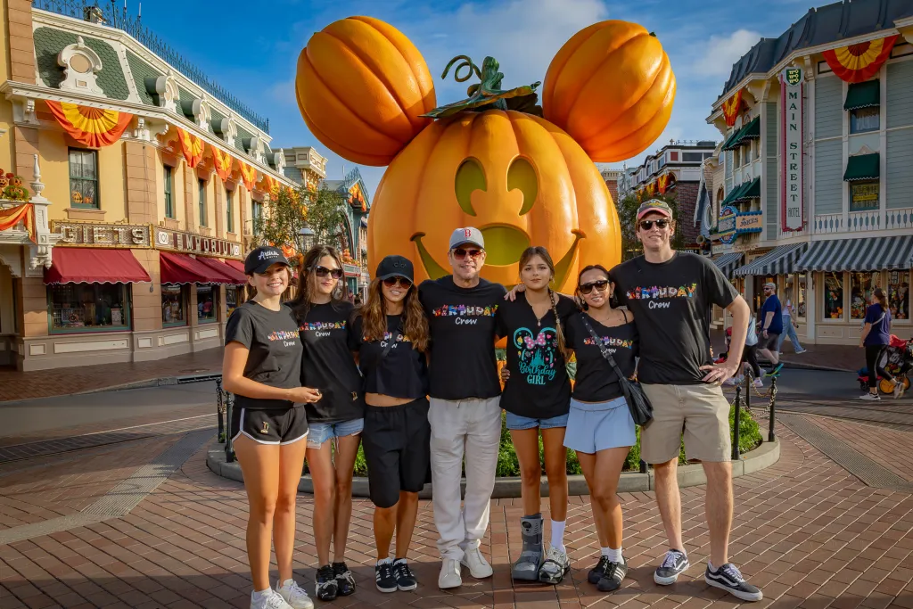 Matt Damon and family in front of a giant Mickey Mouse pumpkin at Disneyland.