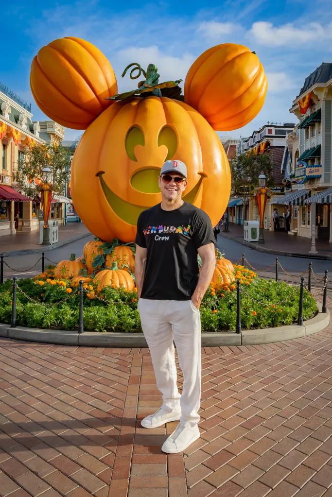 Matt Damon poses in front of a giant Mickey Mouse pumpkin on Main Street, U.S.A., at Disneyland park.