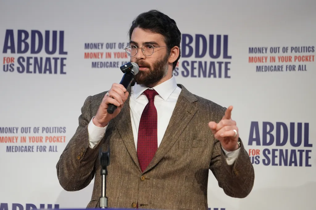 Hasan Piker speaking at a campaign rally for Abdul El-Sayed, with 