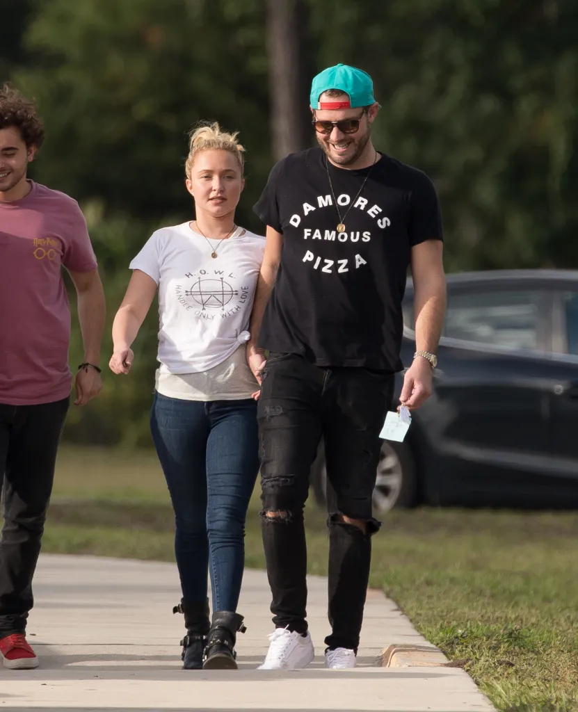 Hayden Panettiere and Brian Hickerson walk hand-in-hand with another person.
