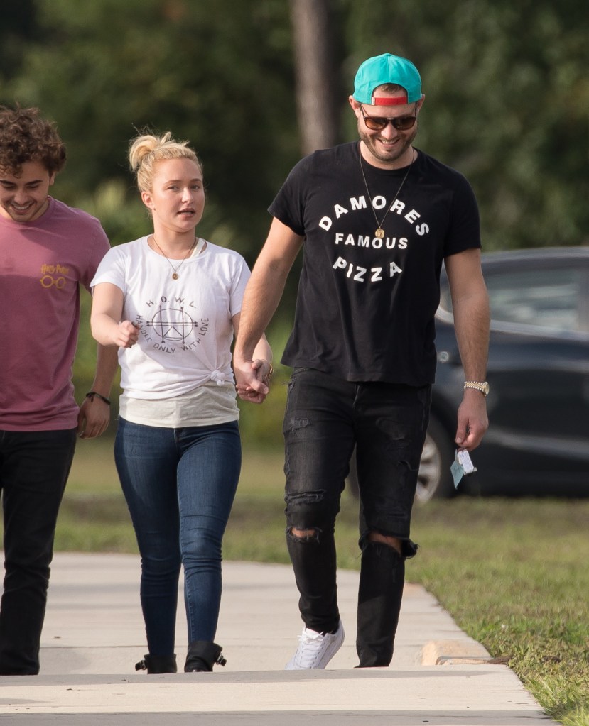 Hayden Panettiere and Brian Hickerson holding hands, walking with another man.