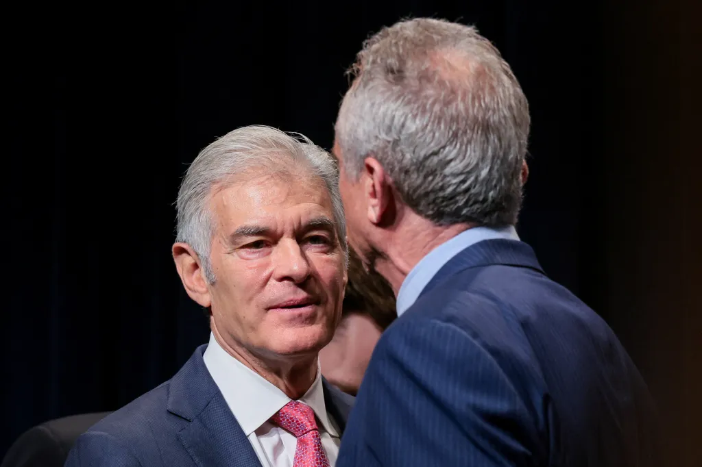 Dr. Mehmet Oz speaks with Robert F. Kennedy Jr. after a press conference to combat healthcare fraud.