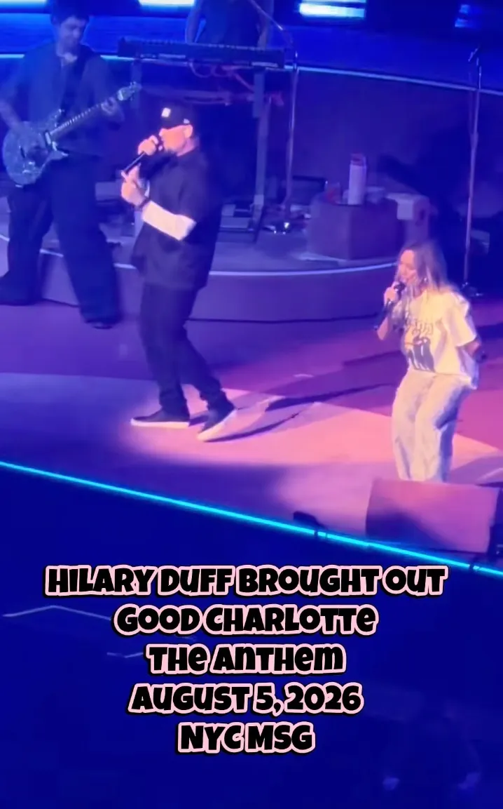 Hilary Duff performing on stage with Joel Madden and a guitarist.