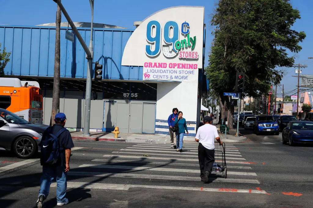 A street scene on Van Nuys Blvd. with a 99 Cents Only Store, people crossing a crosswalk, and cars.