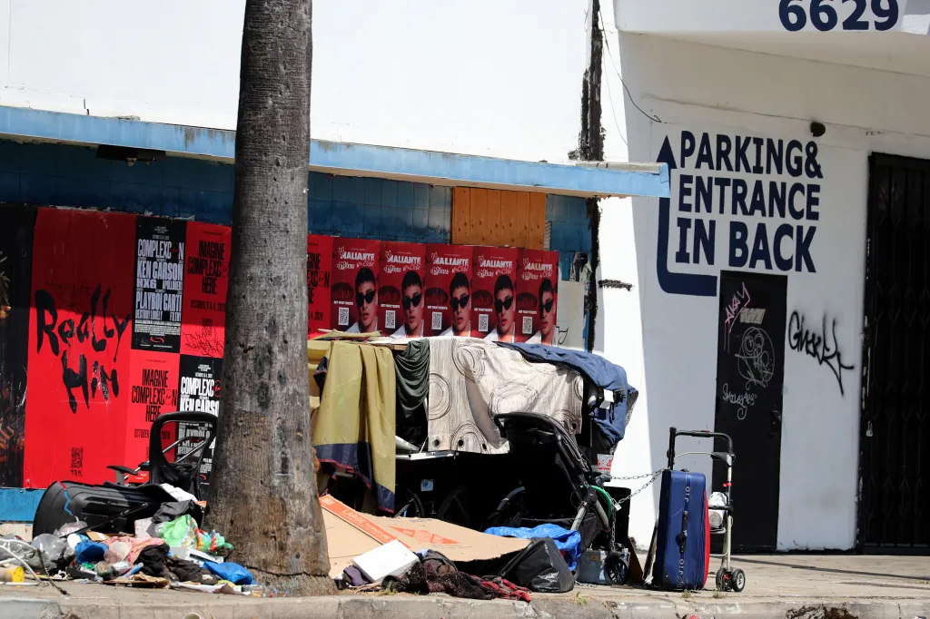 Homeless encampments and closed storefronts line Van Nuys Boulevard.