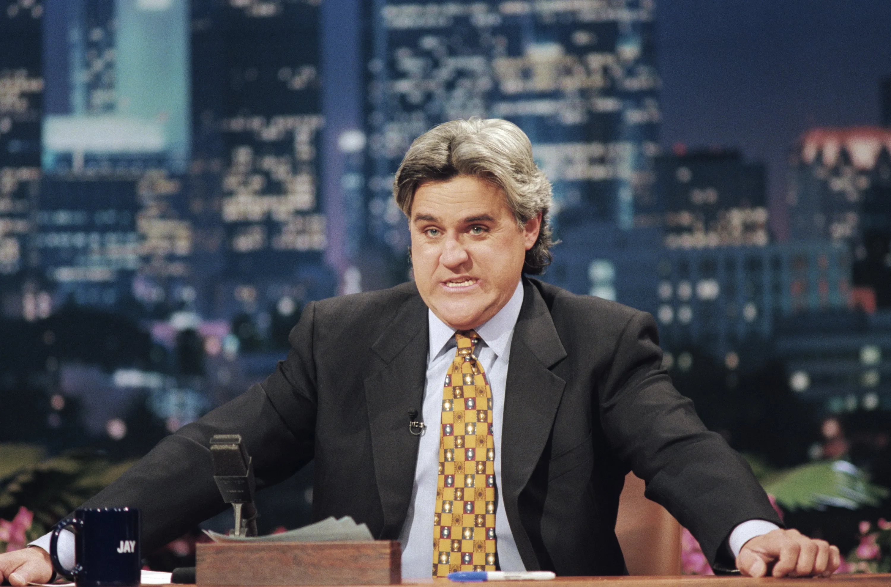 Jay Leno behind his desk on The Tonight Show.