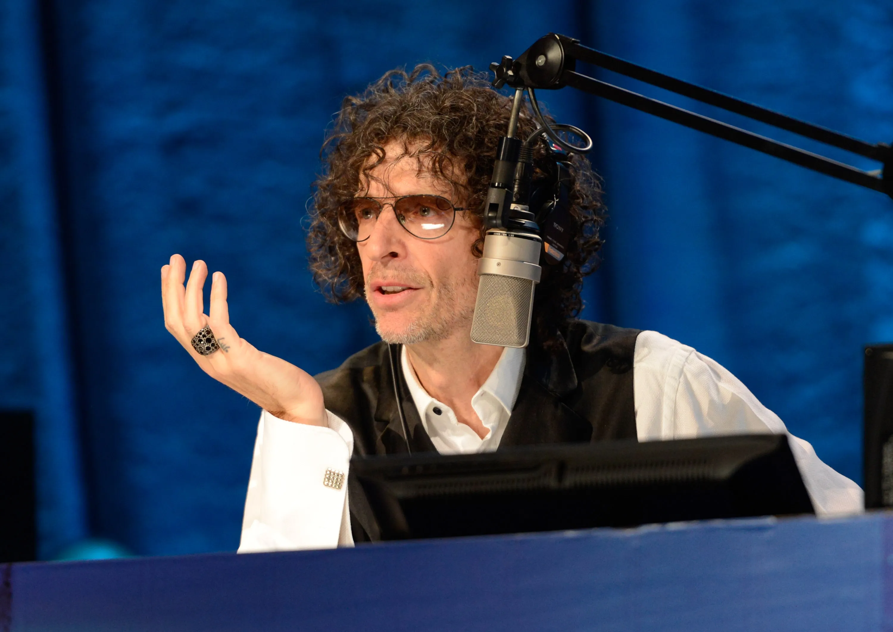 Howard Stern speaking into a microphone at his 2014 Birthday Bash event.