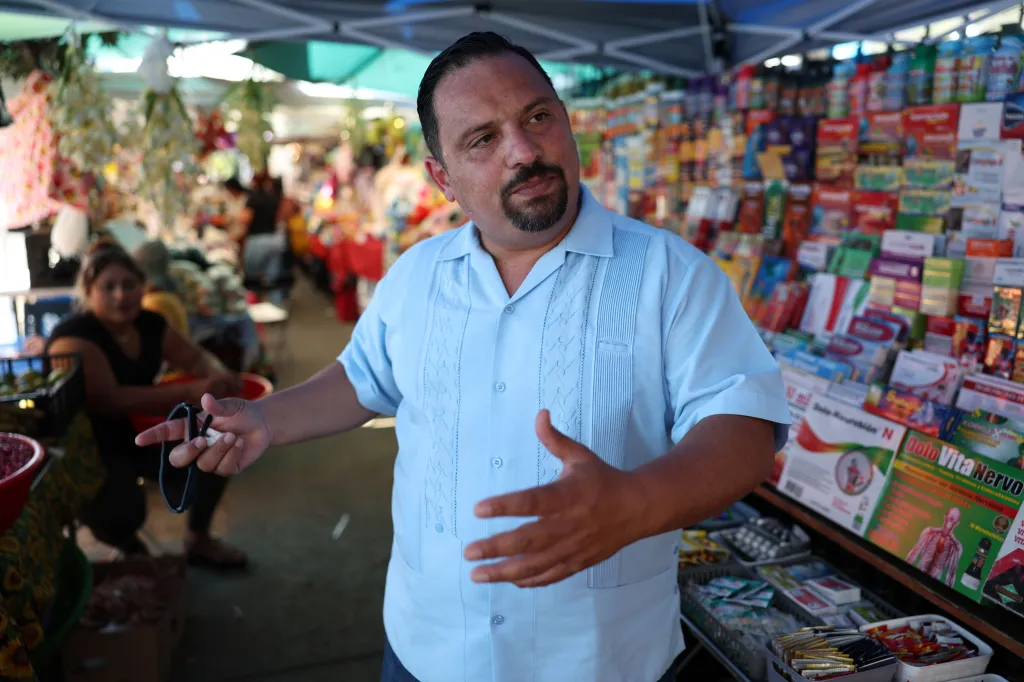 Raoul Claros, executive director of the El Salvador Corridor association, standing in front of street vendor stalls.
