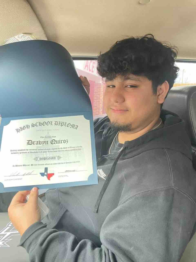 A young man named Dravyn Quiroz holding his High School Diploma from San Antonio, Texas.