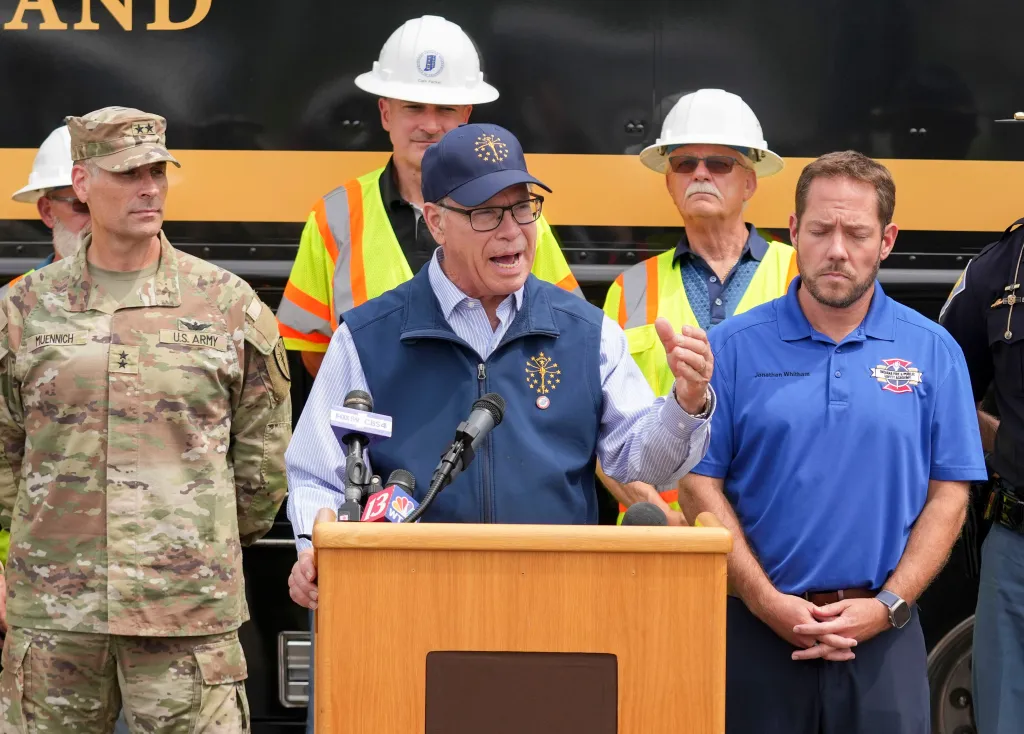Indiana Gov. Mike Braun addresses the media about flooding in Cambridge City, Indiana, alongside military personnel and other officials.
