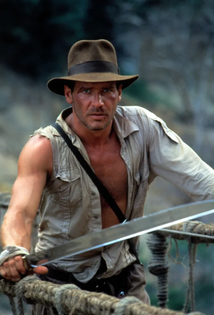 Harrison Ford as Indiana Jones, with a hat, open shirt, and sword, from 