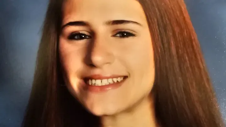 Headshot of Isabell DeLang, a teenage girl with long brown hair, smiling.