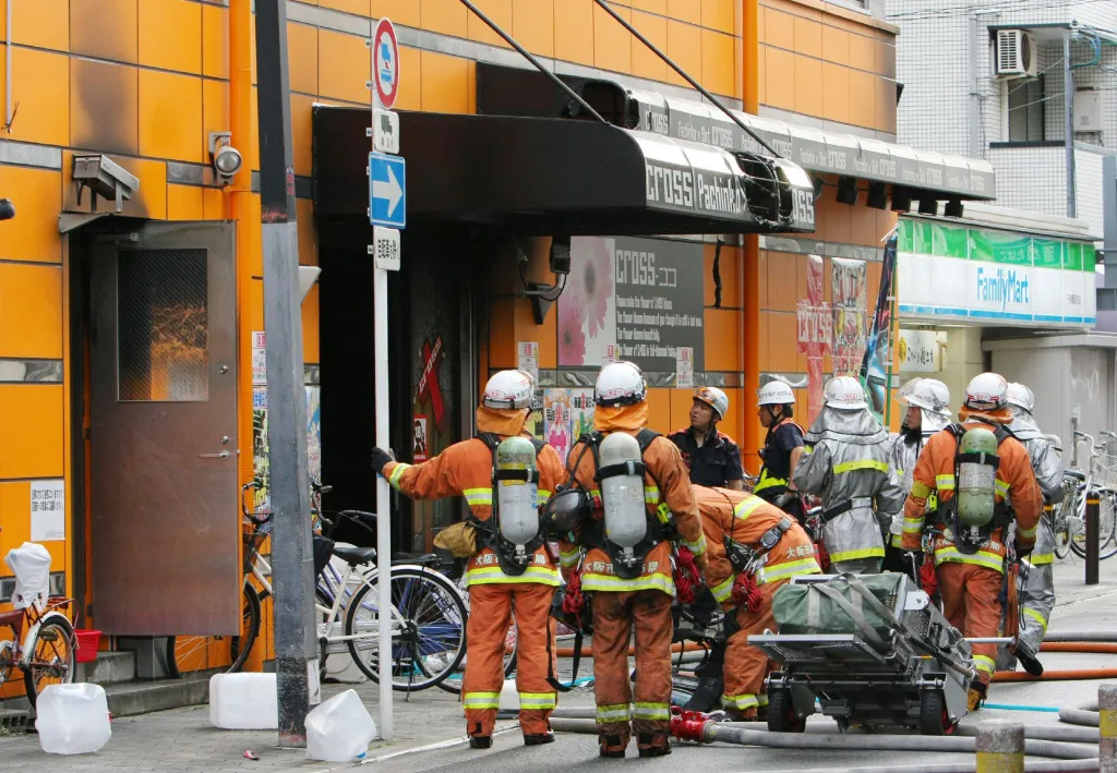 Japanese firefighters work at the scene of an arson attack at a slot machine parlor.
