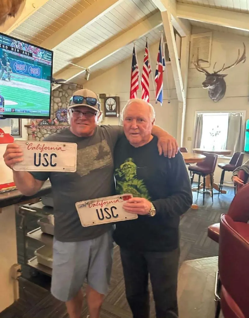 Jeff Grotewold and Mike Stone holding California USC license plates.