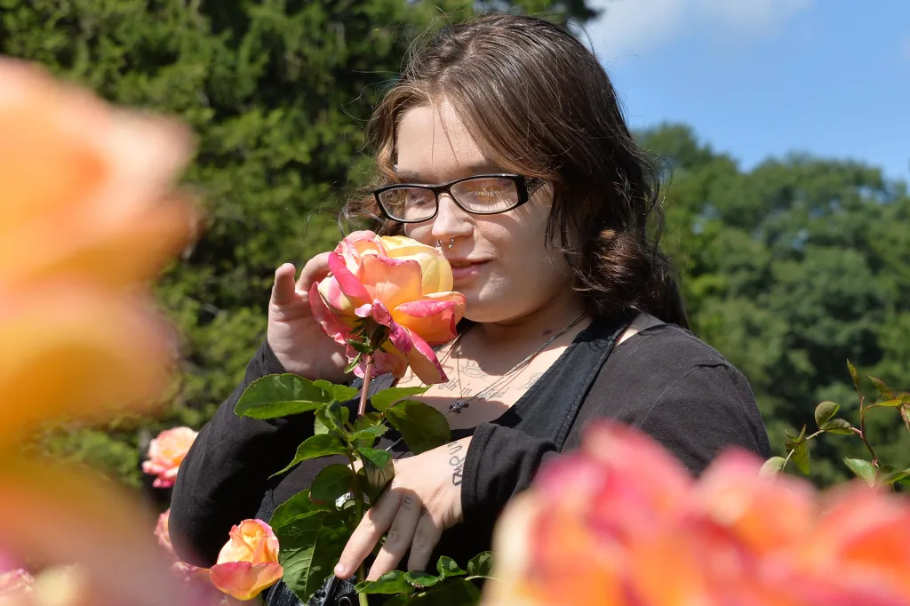 Jessica Bowie smelling a rose at the Central Park Rose Garden.