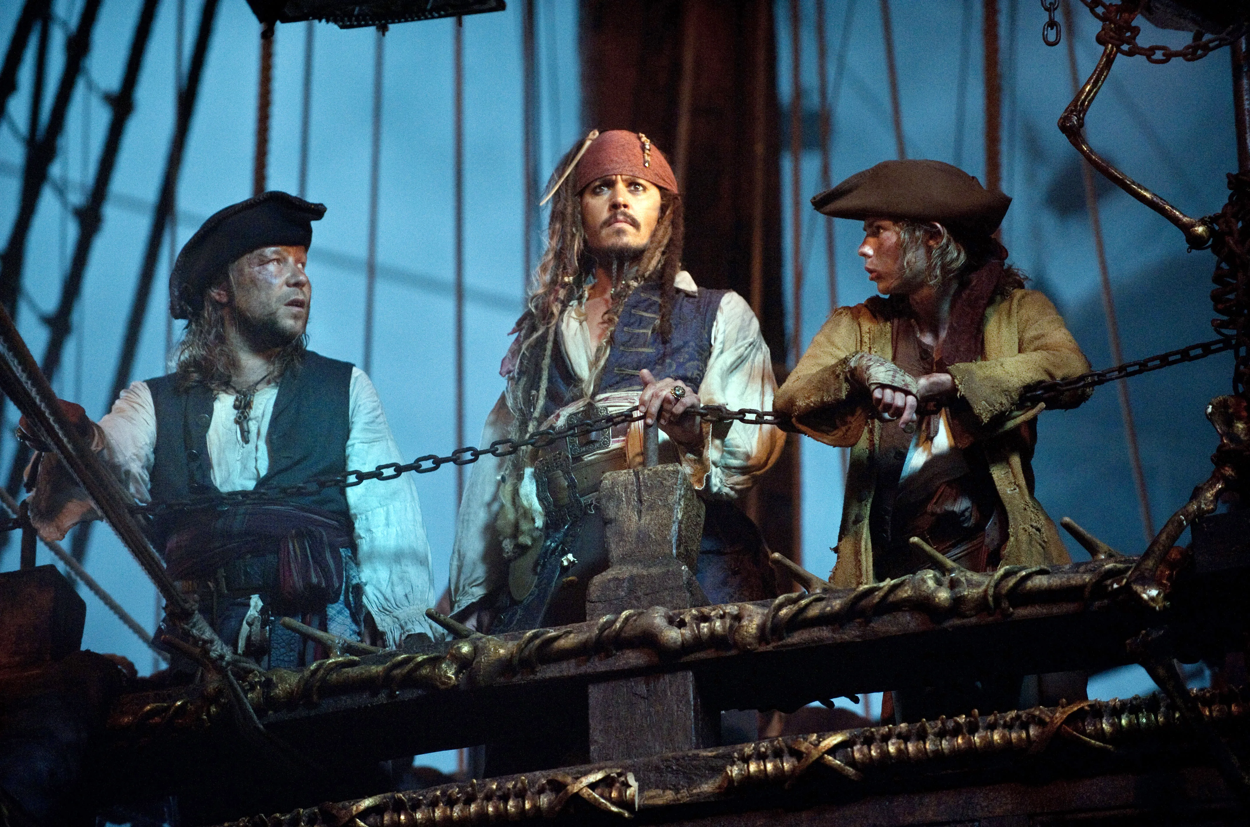 Johnny Depp as Captain Jack Sparrow, Robbie Kay as Cabin Boy, and another pirate in 