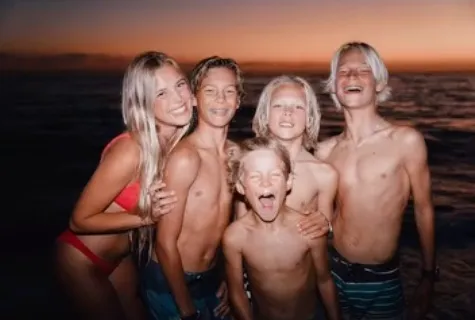 Josh Collette's five children, including a girl in a red bikini and four shirtless boys, smiling and posing together.