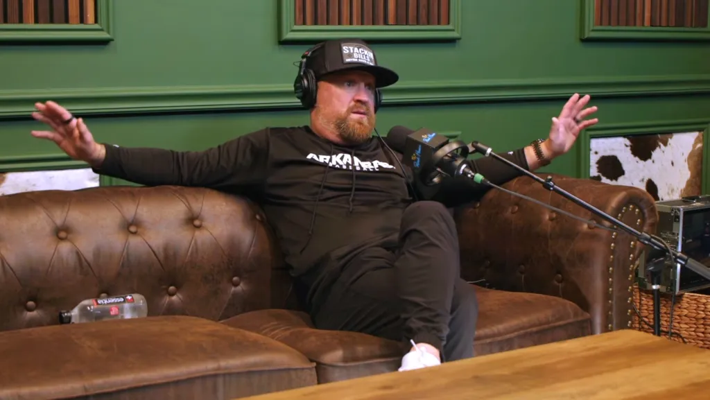 Justin Moore sitting on a couch, talking into a microphone.