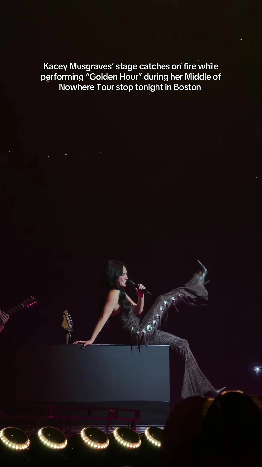 Kacey Musgraves on stage in a sparkly outfit with flames on the stage.