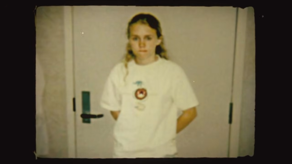 Kara Robinson Chamberlain as a young girl standing in a doorway.