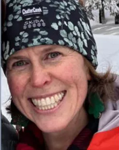 Close-up of Kate Vitt, a smiling woman wearing a dark patterned beanie and winter jacket.