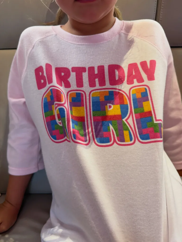 A person wearing a light pink shirt with the words 