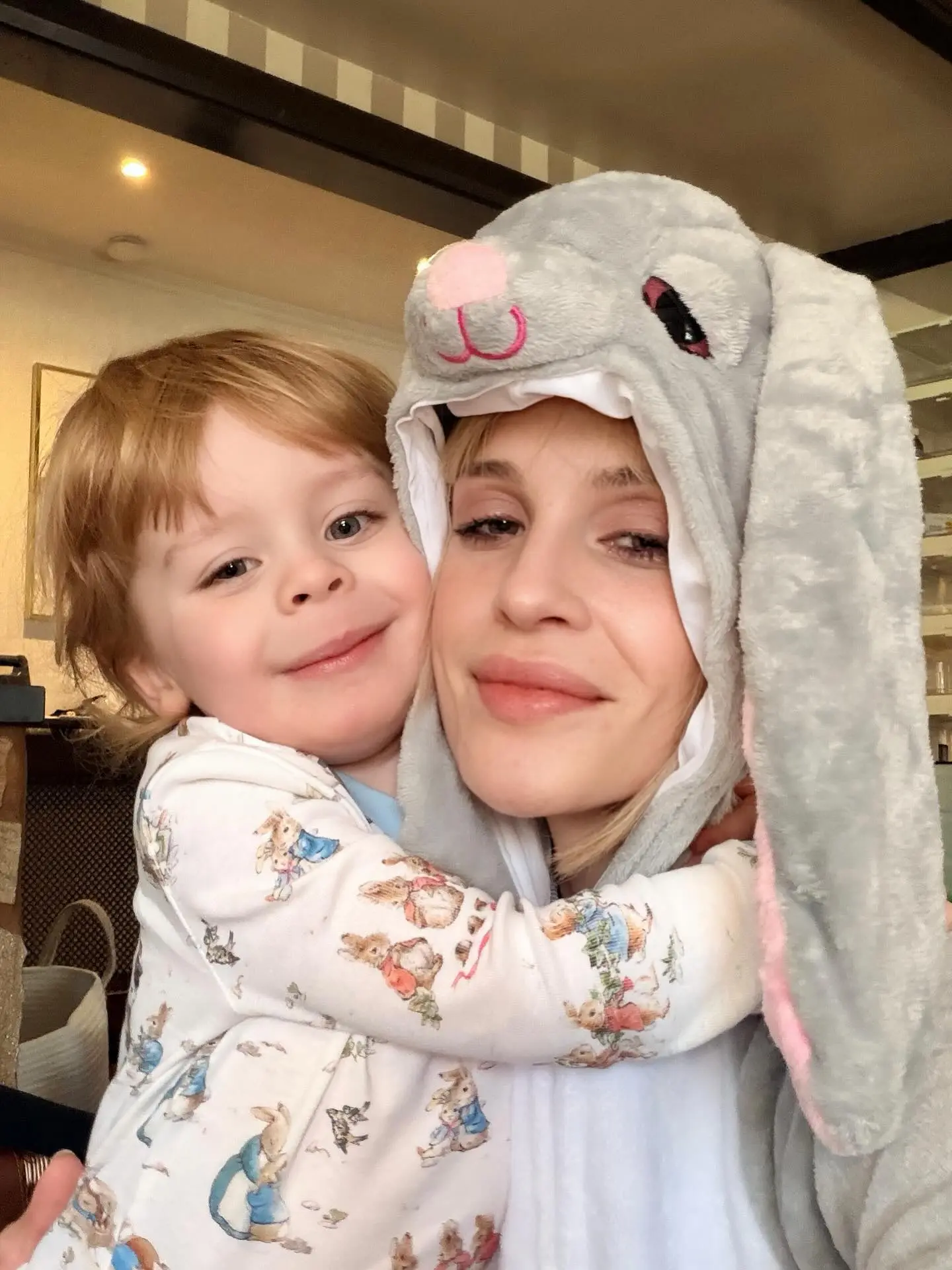 Kelly Osbourne in a bunny costume with her son Sidney, who is wearing Peter Rabbit pajamas.