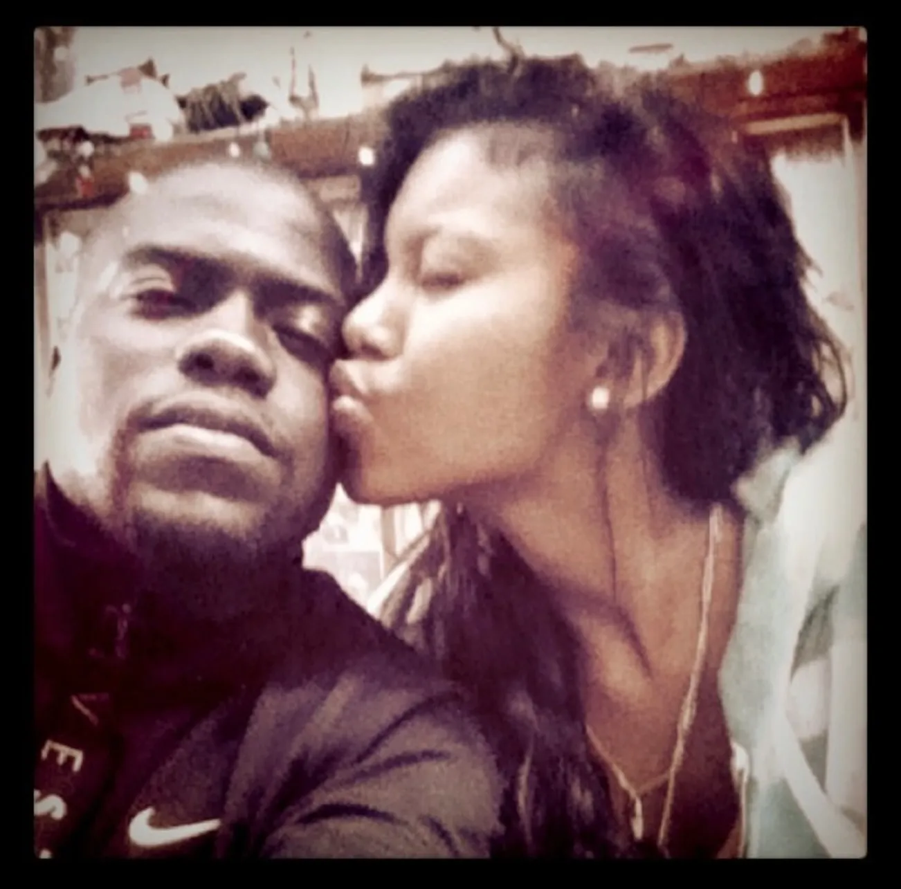 Kevin and Eniko Hart in a close-up selfie, with Eniko kissing Kevin on the cheek.