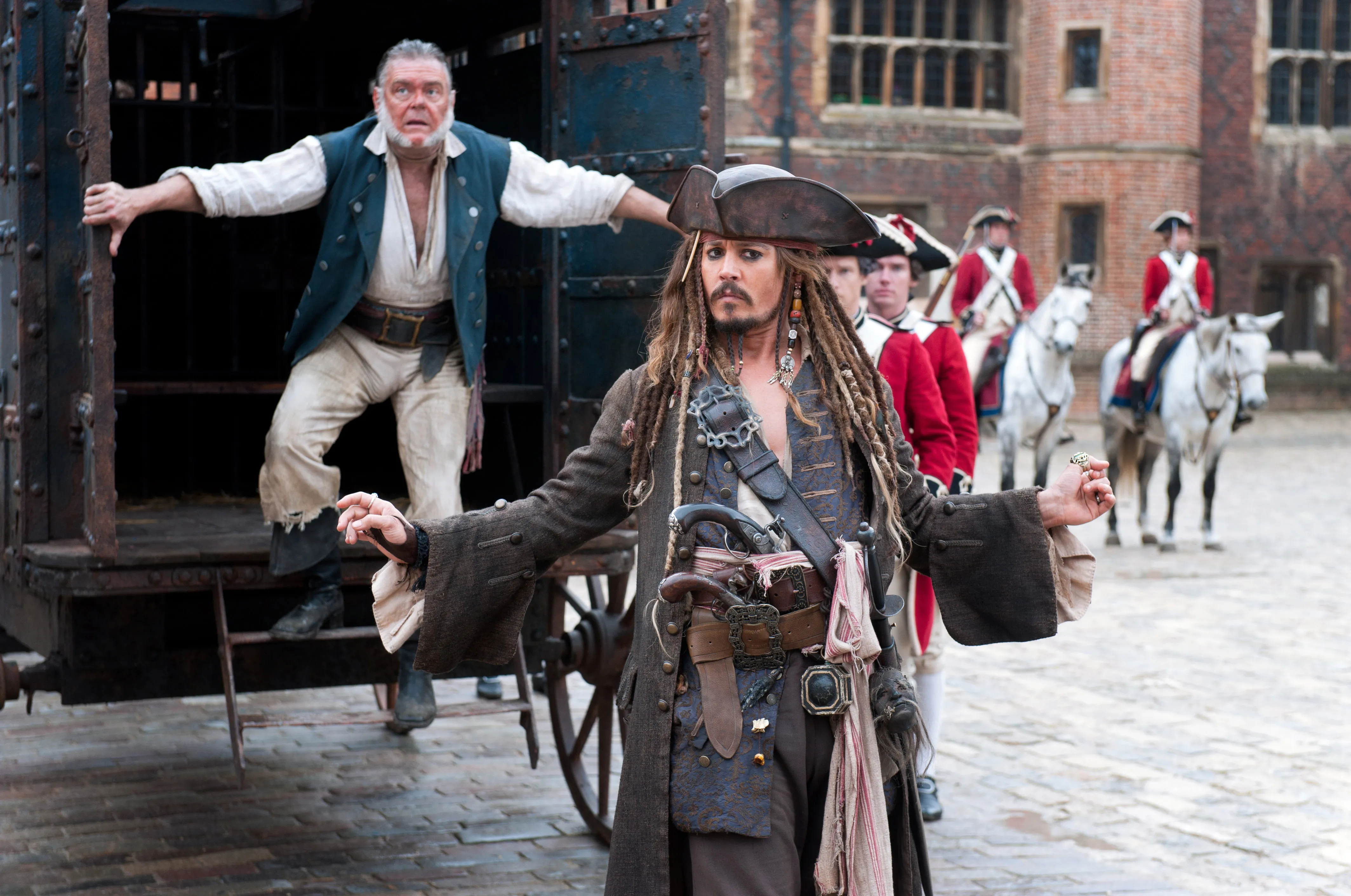 Kevin McNally and Johnny Depp as pirates, with soldiers on horseback in the background.