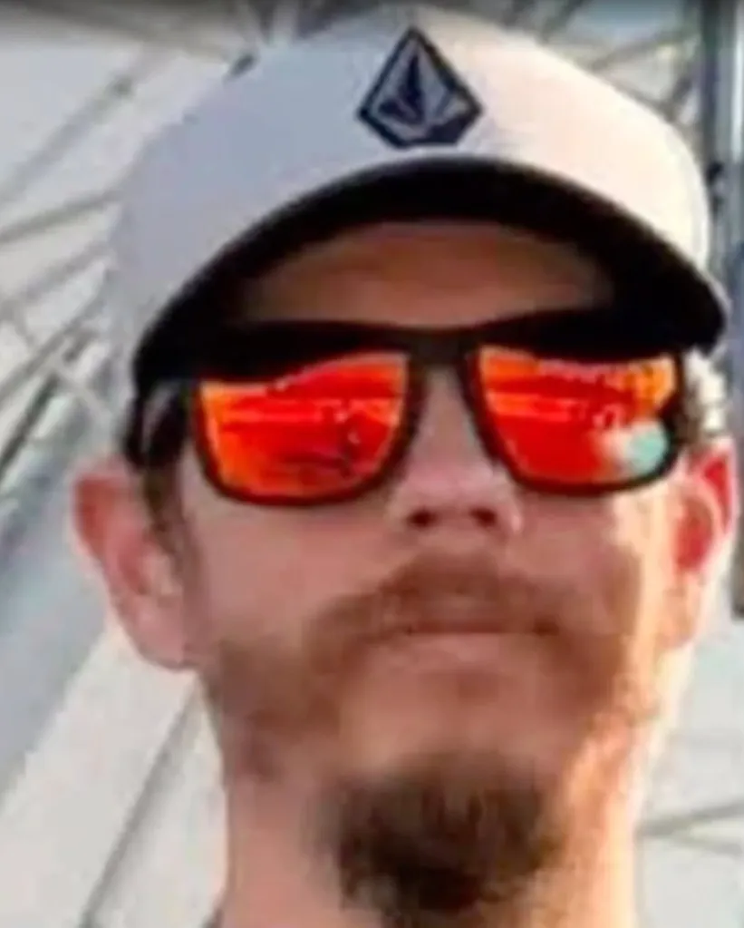 Close-up of a man wearing a baseball cap and sunglasses.